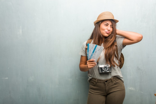 Portret van jonge reiziger Latijnse vrouw tegen een muur die oren behandelt met handen