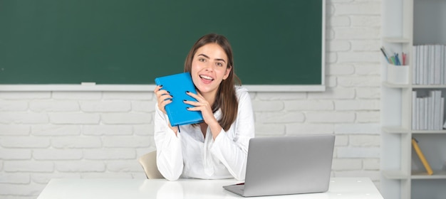 Portret van jonge student met boek studeren in de klas