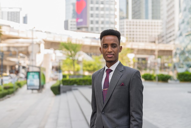 Portret van jonge succesvolle Afrikaanse zakenman buiten in de stad