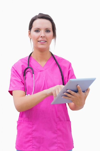 Portret van jonge verpleegster die digitale tablet gebruikt