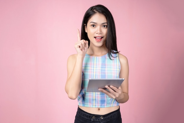 Portret van jonge vrouw die tablet en succes het denken gebruiken