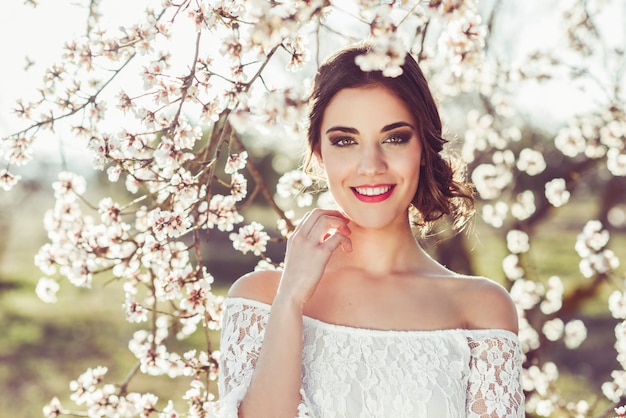 Portret van jonge vrouw in de gebloeide tuin in de de lentetijd