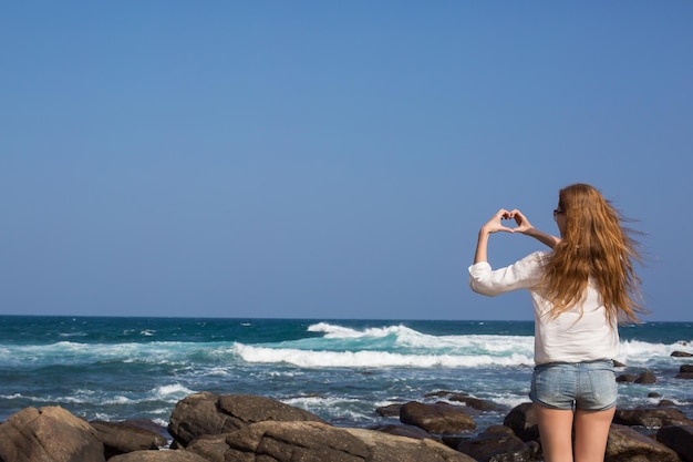 Portret van jonge vrouw in witte bikini op tropisch strand camera kijken Mooi Latijns-meisje in badmode met kopie ruimte Zomervakantie en looien concept