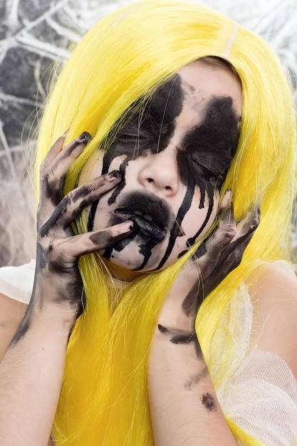 Foto portret van jonge vrouw met geel haar met enge halloween-make-up