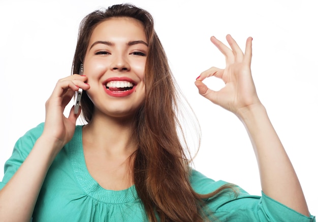 Portret van jonge vrouw op telefoongesprek over witte achtergrond