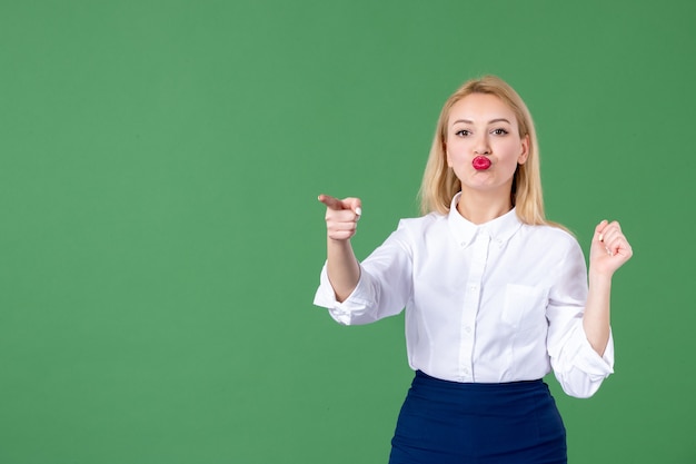 portret van jonge vrouw wijzend in groene muur boek school student college leraar vrouwtjes