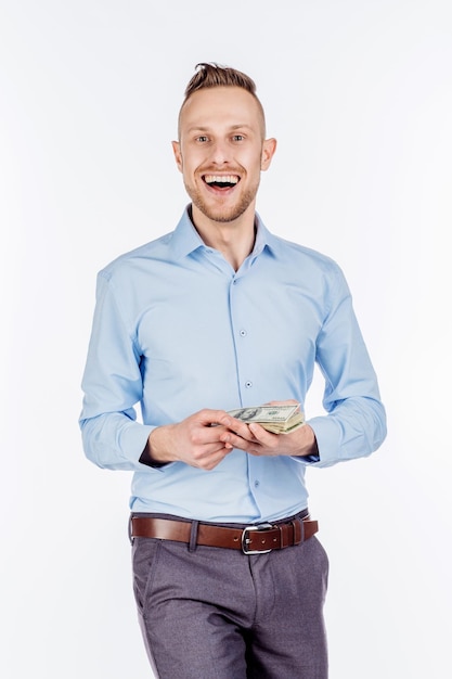 Foto portret van jonge zakenman houden en telt geld dollarbiljetten in handen geïsoleerd op een witte achtergrond emotie gezichtsuitdrukking gevoel financiële beloning besparingen