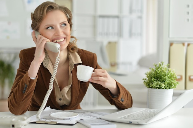Portret van jonge zakenvrouw praten aan de telefoon op kantoor