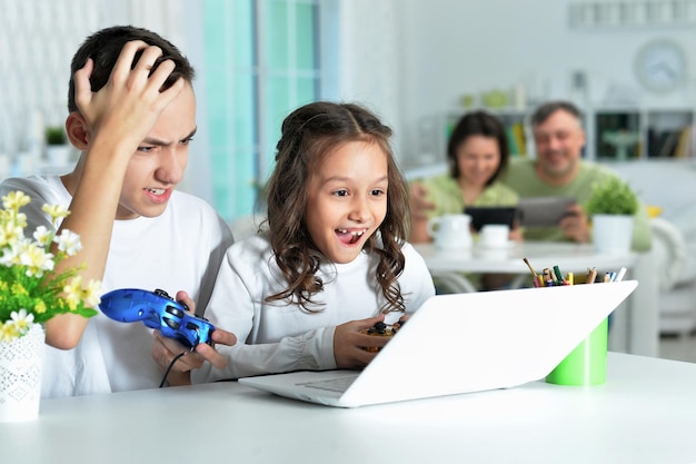 Portret van jongen en meisje die videogame spelen op laptop