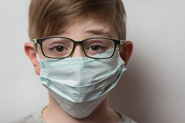 Portret van jongen met bril en medisch masker Kind draagt beschermende gezichtsmaskers