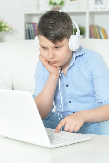 Foto portret van jongen met koptelefoon met laptop