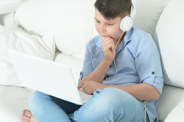 Portret van jongen met koptelefoon met laptop