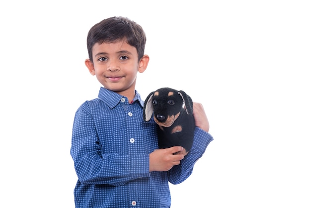 Portret van jongen spelen met zijn knuffeldier huisdier op witte muur