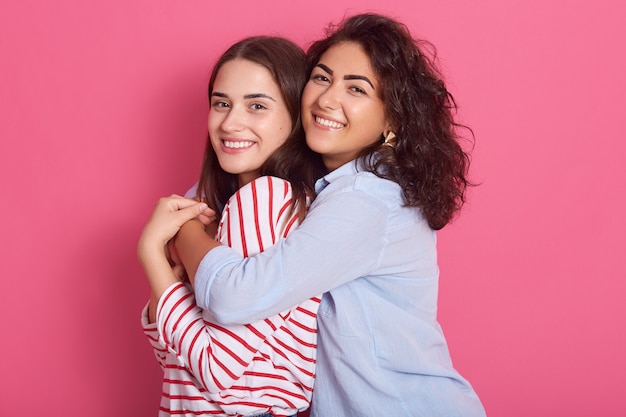 Portret van Kaukasische jonge vrouwen dat over rooskleurig wordt geïsoleerd