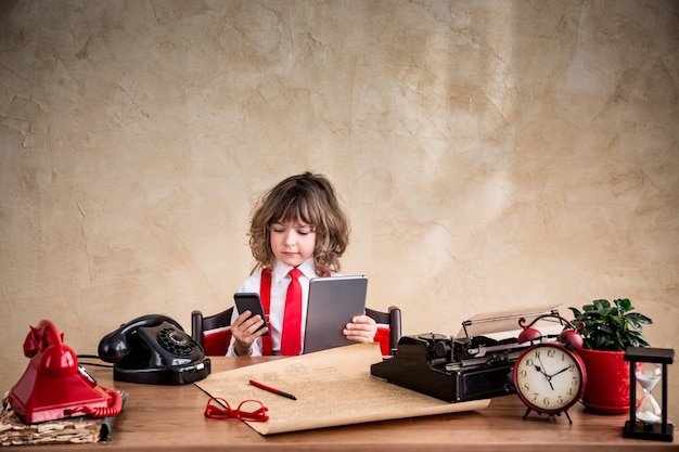 Portret van kind zakenman in kantoor. Kid bedrijf gadgets. Communicatie in bedrijfsconcept