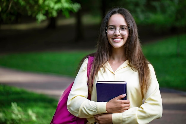 Portret van klaar om enthousiaste vrouwelijke student te studeren op een campusparkpad