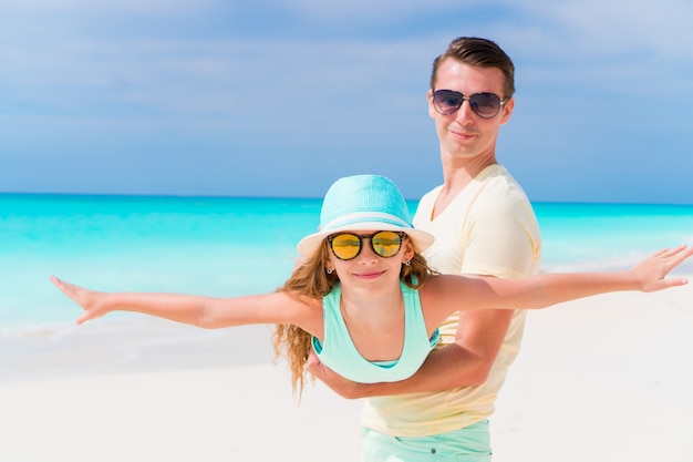 Portret van klein schattig meisje en jonge vader op tropisch strand