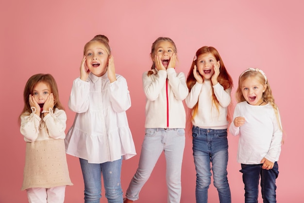 Portret van kleine blanke kinderen met heldere emoties geïsoleerd op roze