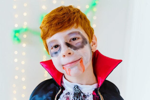 Portret van kleine roodharige jongen gekleed als een griezelige vampier voor Halloween