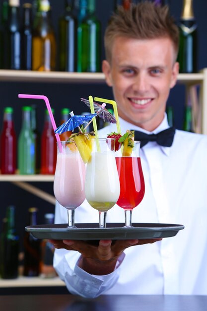 Foto portret van knappe barman met verschillende cocktailscocktail bij bar
