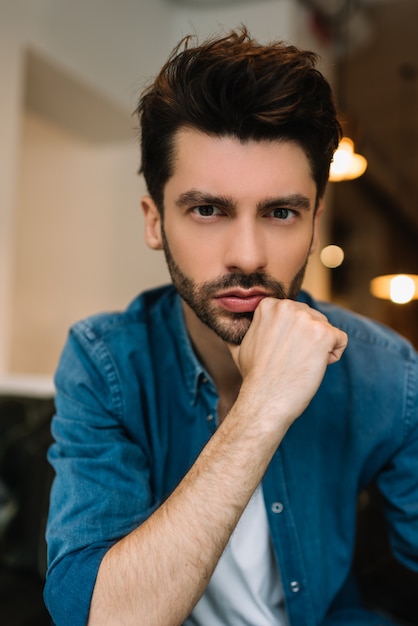 Portret van knappe bebaarde man met stijlvolle kapsel dragen van trendy casual kleding poseren voor foto's