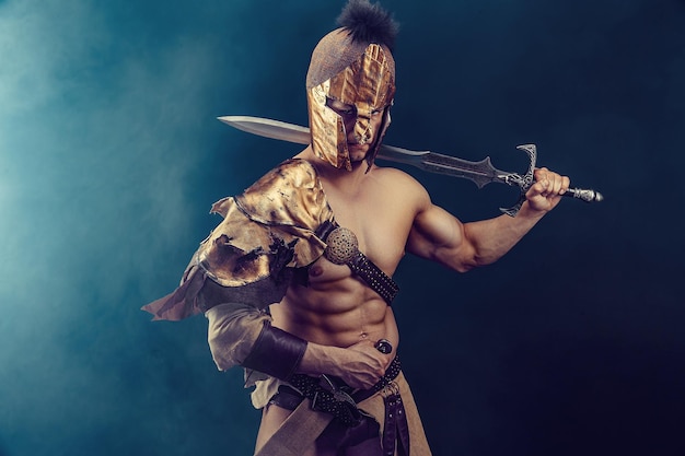 Portret van knappe gespierde gladiator met zwaard Geïsoleerde Studio shot