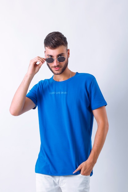 Portret van knappe glimlachende stijlvolle jonge man model gekleed in de blueTshirt fashion man pos