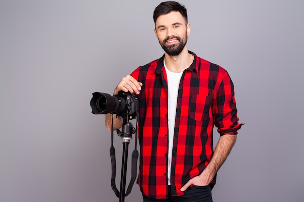 Portret van knappe jonge cameraman die zich in studio met camera bevindt