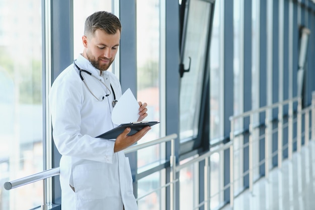 Portret van knappe jonge dokter op ziekenhuisgang