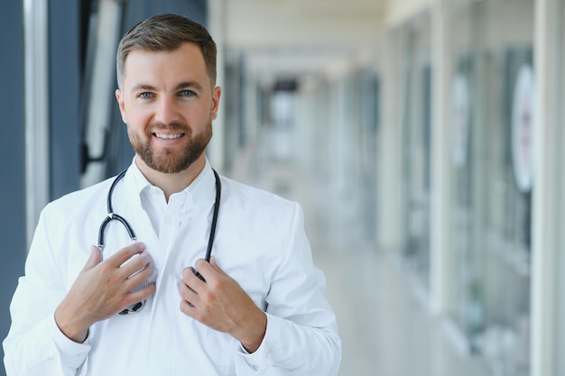 Portret van knappe jonge dokter op ziekenhuisgang