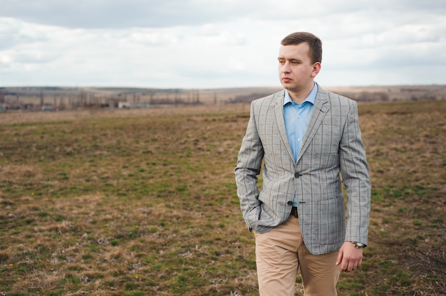 Portret van knappe jonge man in een veld.