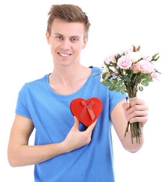 Portret van knappe jonge man met bloemen en cadeau, geïsoleerd op wit
