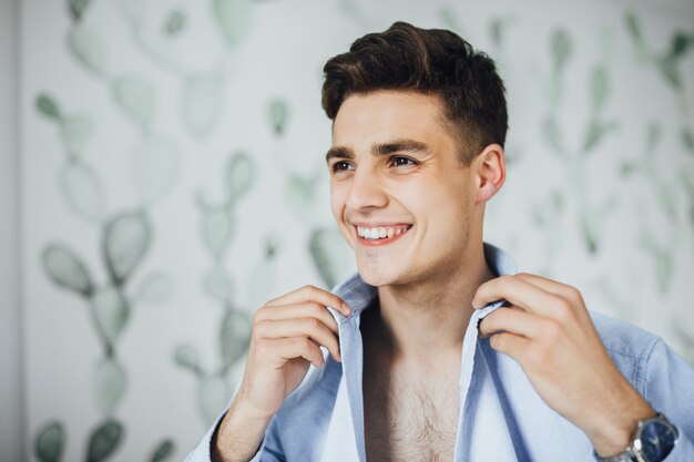 Portret van knappe jongen die een shirt in de ochtend draagt en glimlacht