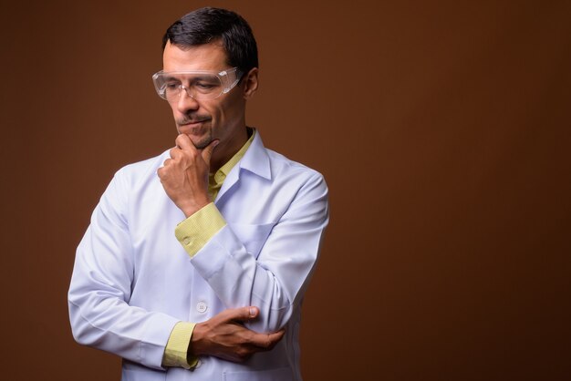 Portret van knappe man arts beschermende bril dragen tijdens het denken