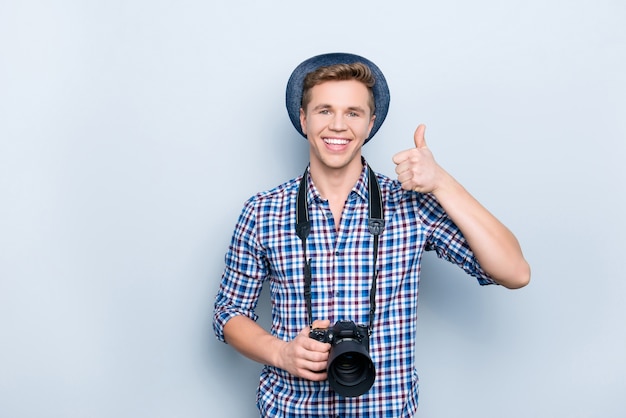 Portret van knappe man met camera duimen opgevend