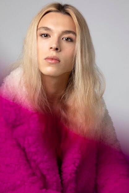 Foto portret van knappe man met lang blond haar en pluizig jasje