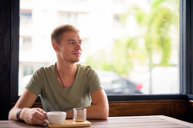 Portret van knappe man ontspannen in de coffeeshop