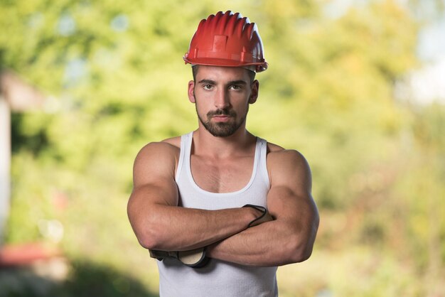 Portret van knappe mannelijke architect-ingenieur met gele helm