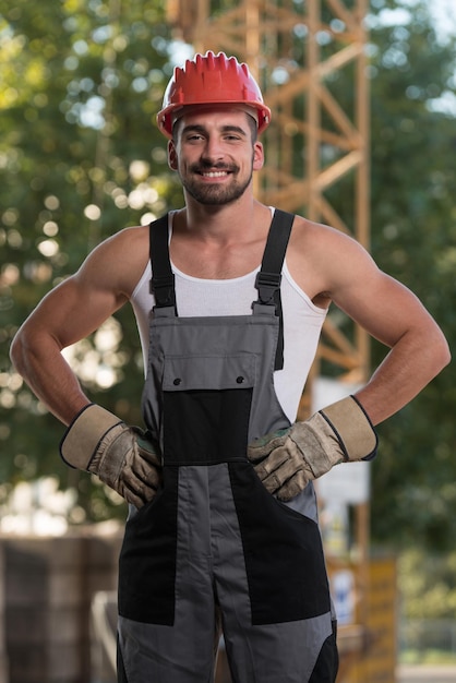 Portret van knappe mannelijke architect-ingenieur met rode helm