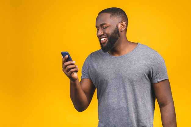 Portret van knappe opgewonden vrolijke vreugdevolle heerlijke nieuwsgierige man dragen van casual verzenden en het ontvangen van berichten naar zijn geliefde. Telefoon gebruiken.