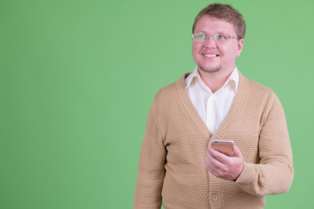 Portret van knappe overgewicht bebaarde man met bril tegen Chromakey of groene muur