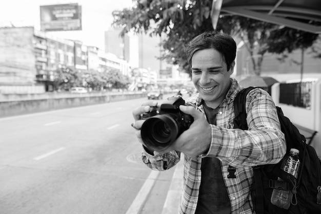 Portret van knappe perzische toeristische man vakantie doorbrengen en het verkennen van de stad bangkok in zwart-wit