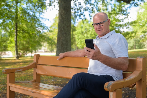 Portret van knappe senior man ontspannen in het park