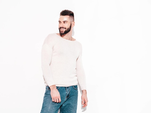 Portret van knappe zelfverzekerde model Sexy stijlvolle man Mode hipster man poseren in de buurt van muur in studio