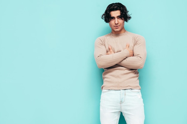 Portret van knappe zelfverzekerde stijlvolle hipster lamberseksueel model man gekleed in zomerkleren mode man geïsoleerd in studio poseren in de buurt van blauwe muur