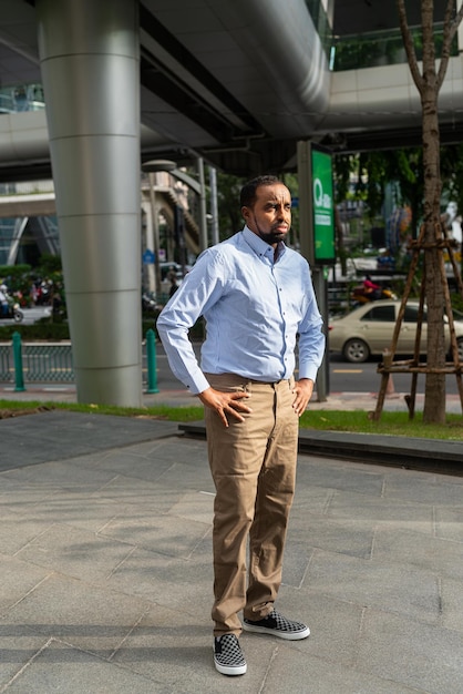 Portret van knappe zwarte man in stad klaar voor zaken