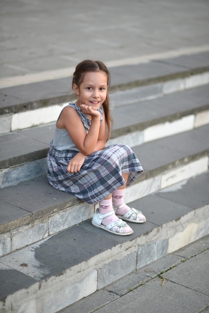 Foto portret van lachend meisje zittend op de trap