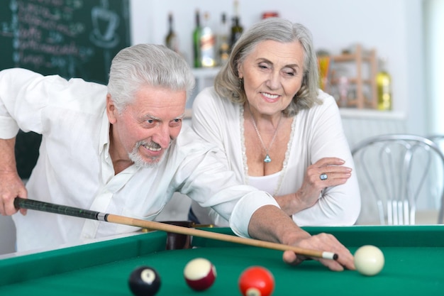 Portret van lachend senior koppel dat samen biljart speelt