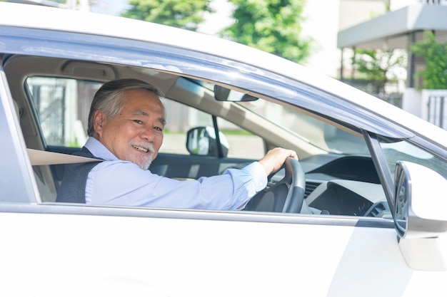 Portret van lachende Aziatische senior man, oude man, oudere man goede gezondheid autorijden