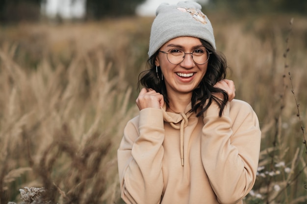 portret van lachende brunette meisje in glazen in het veld